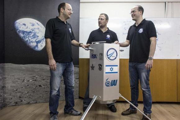 The co-founders of SpaceIL Bash, Damari and Winetraub stand next to their company's spacecraft process prototype near Tel Aviv