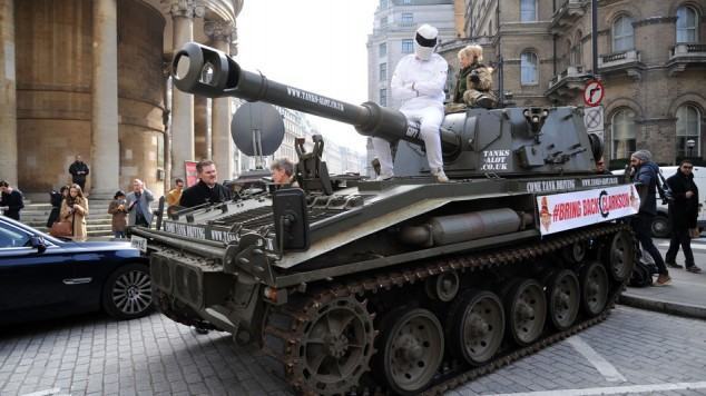 Man dressed (poorly) as The Stig sat on cannon of tank hired by #BringBackClarkson campaign Campaign to reinstate Jeremy Clarkson on Top Gear outside BBC Broadcasting House, London, Britain - 20 Mar 2015  (Rex Features via AP Images)