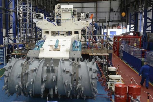 Employees of Soil Machine Dynamics (SMD) work on a subsea mining machine being built for Nautilus Minerals at Wallsend, northern England April 14, 2014. High-tech advances, depleted easy-to-reach minerals onshore and historically high prices have boosted the idea of mining offshore, where metals can be fifteen times the quality of land deposits. The world's first deep sea mining robot sits idle on a British factory floor, waiting to claw up high grade copper and gold from the seabed off Papua New Guinea (PNG) - when a wrangle over terms is solved. Built by SMD, it will put Canadian listed Nautilus Minerals on course to become the first company to commercially mine in deep water. Picture taken April 14.   REUTERS/ Nigel Roddis  (BRITAIN - Tags: SOCIETY BUSINESS COMMODITIES)