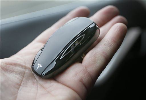 In a photo from Tuesday, April 7, 2015 in Detroit, the key fob of the new Tesla Model S 70D, which resembles a toy car, is seen during a test drive. Electric car maker Tesla Motors is seeking mainstream luxury buyers by adding all-wheel-drive and more range and power to the base version of its only model. Starting Wednesday, Tesla will stop selling the old base Model S called the 60 and replace it with the 70-D. The new car can go 240 miles per charge and from zero to 60 in 5.2 seconds. (AP Photo/Carlos Osorio)