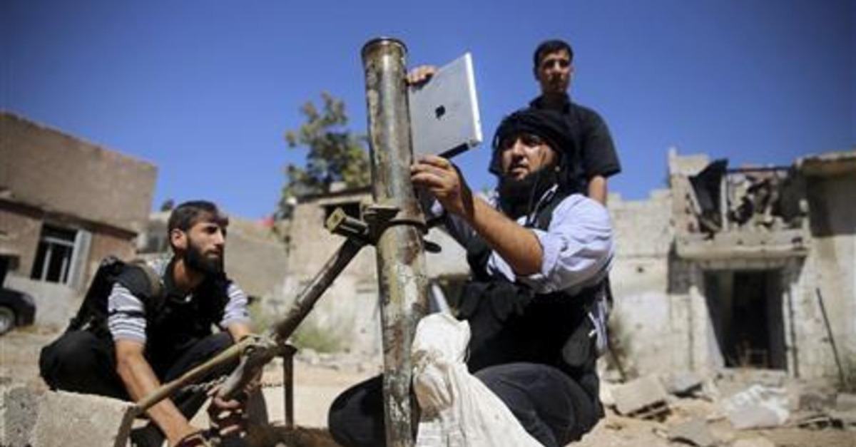 A member of the 'Ansar Dimachk' Brigade, part of the 'Asood Allah' Brigade which operates under the Free Syrian Army, uses an iPad during preparations to fire a homemade mortar at one of the battlefronts in Jobar, Damascus September 15, 2013. REUTERS/ Mohamed Abdullah