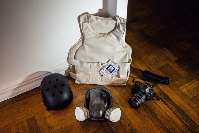 A level IIIA Kevlar vest, 3M respirator fitted with gas and vapor-proof cartridges, a lightweight skateboarders helmet, Canon 5D Mark 3 digital camera with 24-70/f4 lens and press identification card.