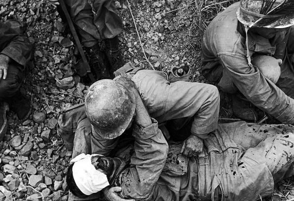 A soldier from the US 7th Army Division comforts a wounded comrade during the fight for Okinawa, Japan, May 1945. (Photo by W. Eugene Smith/Time & Life Pictures/Getty Images)