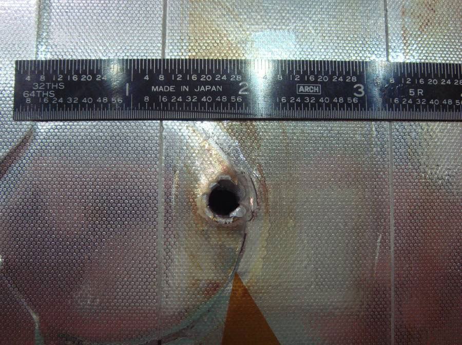 Buraco no ônibus espacial Endeavour, causado por lixo orbital ou um micro-asteróide.