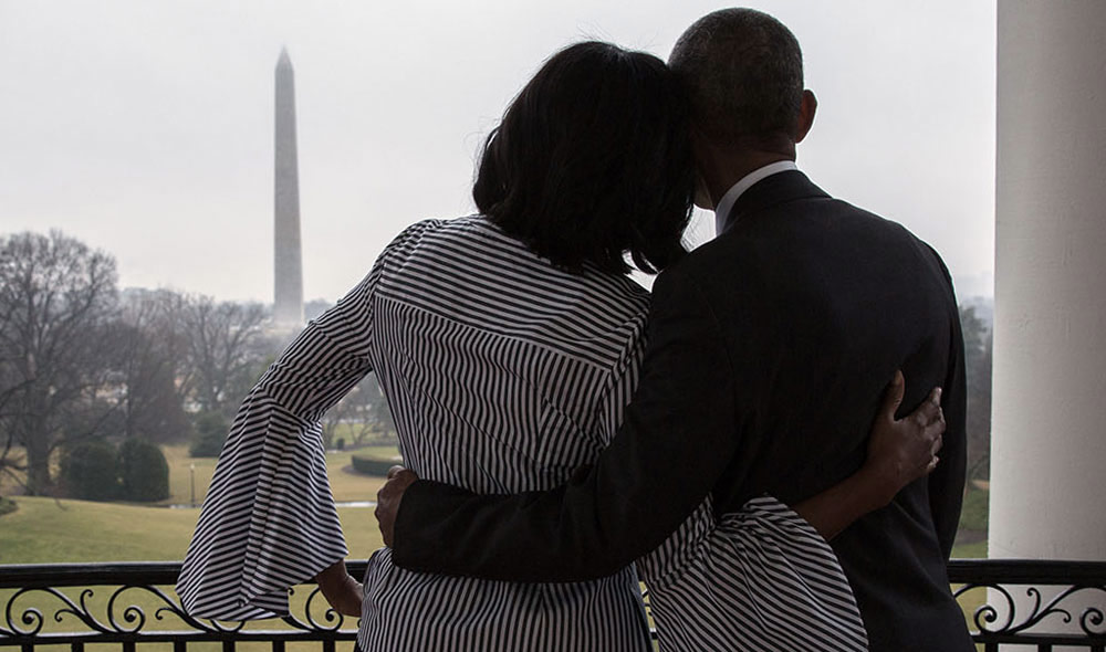 Casal Michelle e Barack Obama de costas observando a vista da Casa Branca