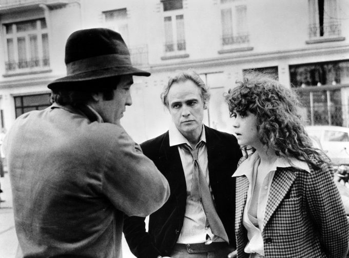 Bernardo Bertolucci dirigindo Marlon Brando e Maria Schneider em uma cena de O Último Tango em Paris