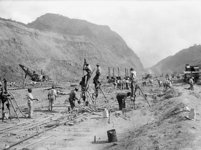 Panama Canal construction in 1913 showing workers drilling holes for dynamite in bedrock, as they cut through the mountains of the Isthmus. Steam shovels in the background move the rubble to railroad cars. (Everett Historical/Shutterstock) / canal do panamá