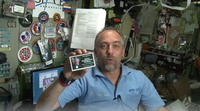 Richard Garriott a bordo da ISS em 2008, exibindo um dos cartões com as cinzas de Scotty (Crédito: Reprodução/The Times)