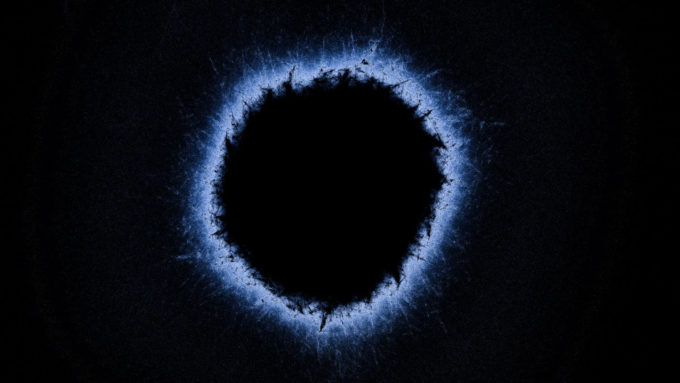 Representação artística de um buraco negro com diversos pontos de instabilidade gravitacional na região do Horizonte de Eventos (Crédito: Getty Images)