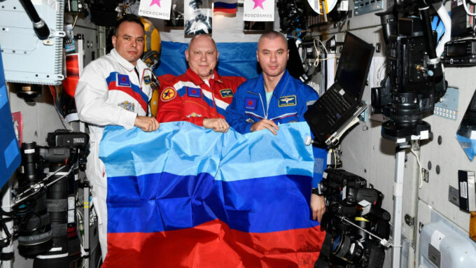 Cosmonautas russos Sergey Korsakov, Oleg Artemyev e Denis Matveev exibem bandeira da República Popular de Lugansk na ISS (Crédito: Roscosmos/Telegram)