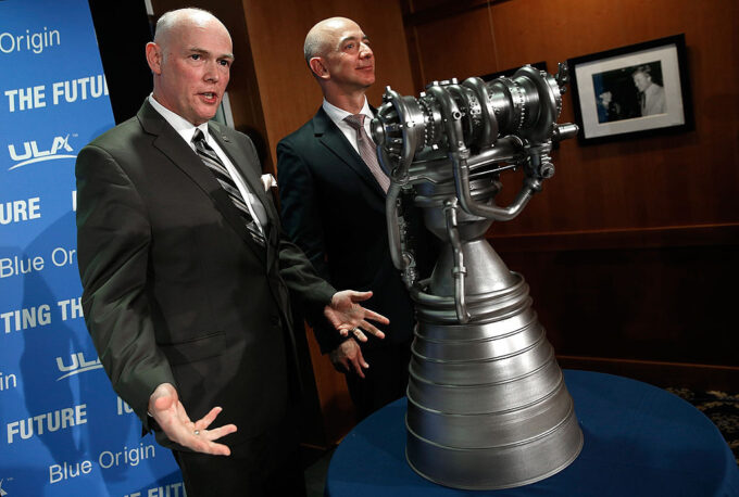 Tory Bruno (esq.), CEO da ULA, e Jeff Bezos, durante coletiva de imprensa em 2014, exibindo modelo do motor BE-4, fornecido pela Blue Origin (Crédito: Win McNamee/Getty Images)