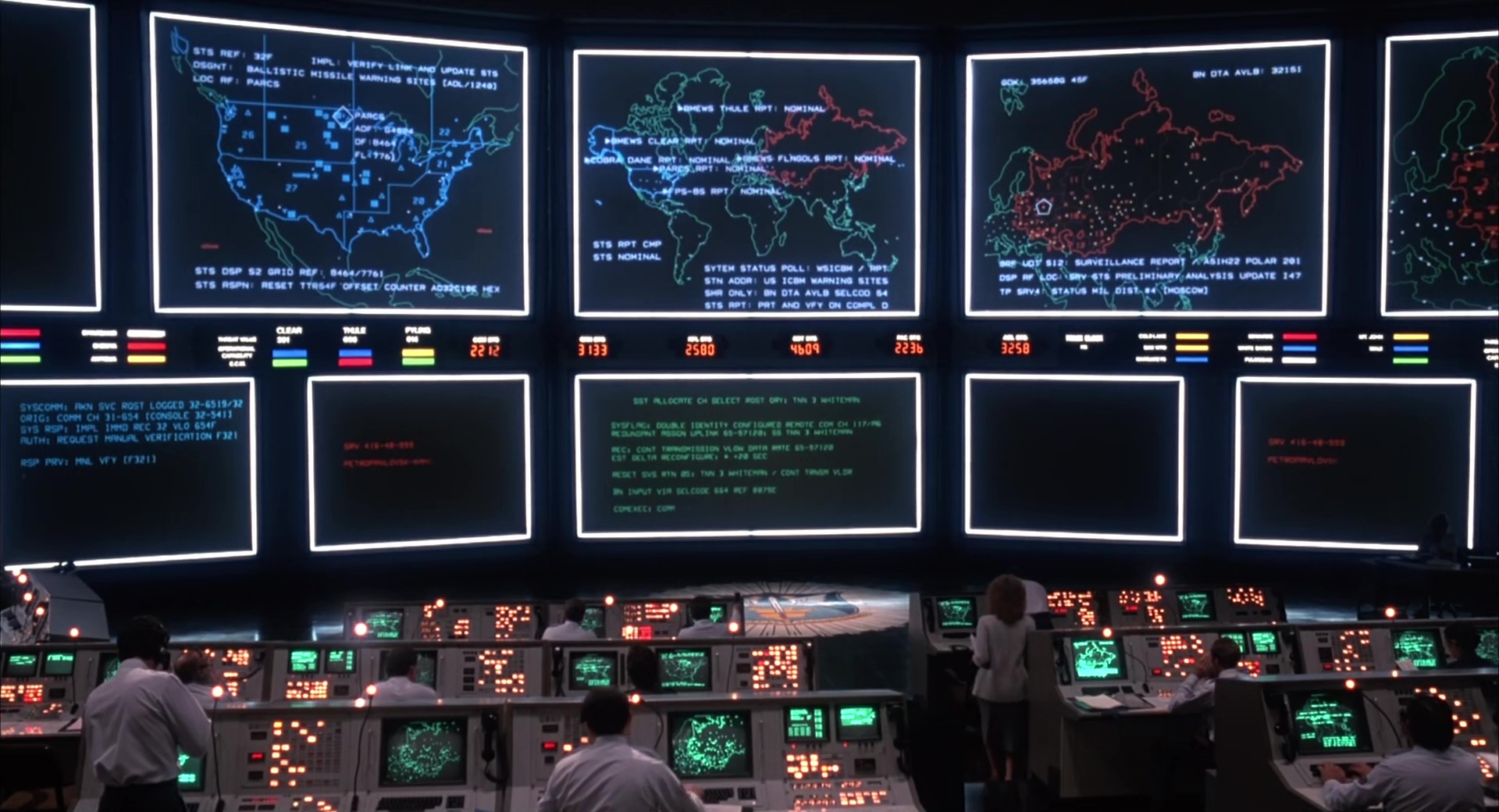 Imagem de um centro de controle de defesa antimísseis americano da era da Guerra Fria. Vários monitores gigantes na parede mostram mapas do continente americano, Europa e Rússia com pontos e linhas indicando sites de alerta de mísseis (como Thule, Clear, Fylingdales, Beale), códigos de status (STS REF, BN OTA AVLB, DSP LOC), relatórios de lançamento e contagens numéricas (223b, 3250, 4609). Operadores uniformizados trabalham em estações de console iluminadas por luz verde neon, com teclados, telas CRT e painéis de botões coloridos. A cena transmite tensão estratégica, tecnologia retro e vigilância global.