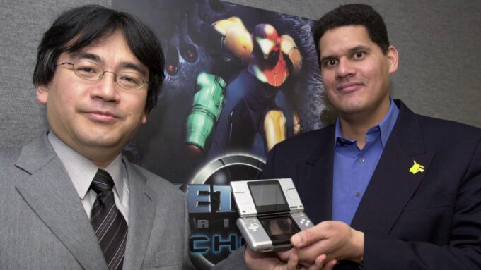 Satoru Iwata (1959—2015) e Reggie Fils-Aimé, respectivamente ex-presidente da Nintendo e ex-presidente e COO da Nintendo of America, exibem o então novo Nintendo DS, durante a E3 2004 (Crédito: Susan Goldman/Bloomberg/Getty Images)