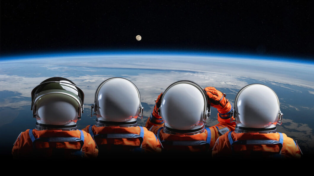 Arte referente ao programa Artemis da NASA, mostra quatro astronautas em trajes espaciais observando a Lua à distância, estando aparentemente suspensos na órbita da Terra (Crédito: Divulgação/NASA)