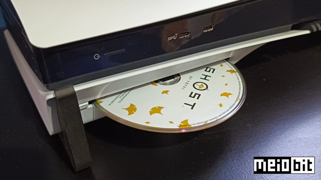 Mídia física do game Ghost of Yōtei posicionada no leitor de discos do PS5 Pro (Crédito: Ronaldo Gogoni/Meio Bit)